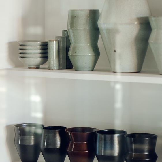 Two shelves with varied in size ceramic vessels