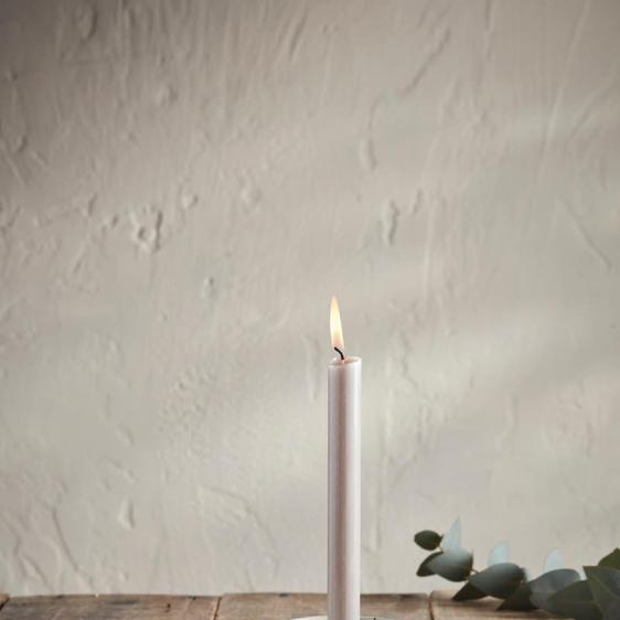 White, lit candle in a white candle holder