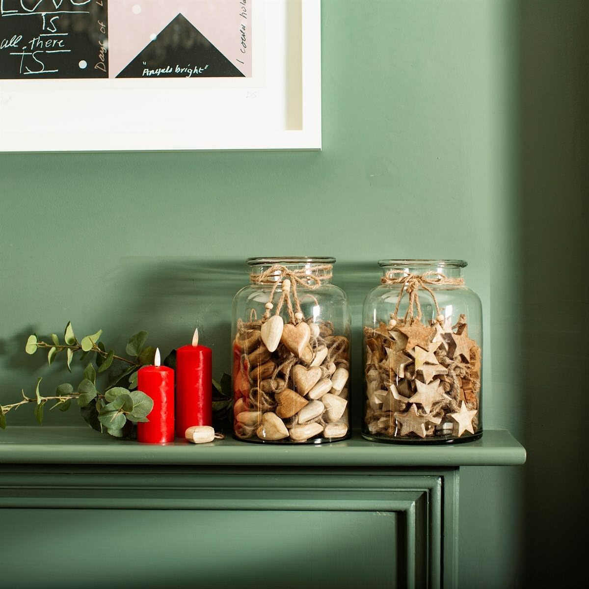 Wooden decorations in two glass jars on a mantelpiece