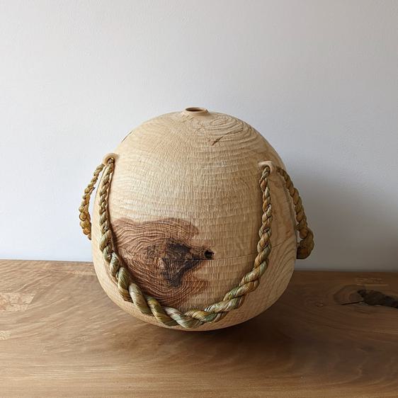 Large wooden vessel with twisted rope tied around it