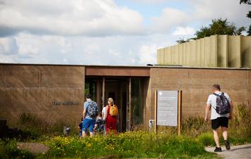 People walking into a low building