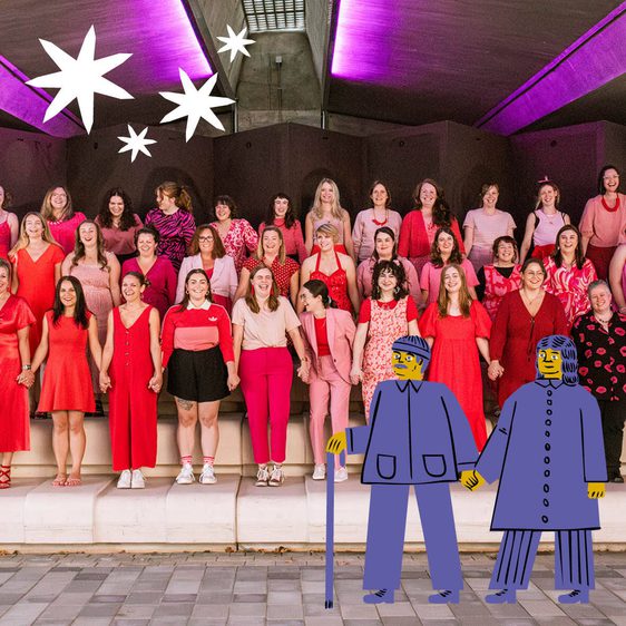 A group of women dressed in red and pink stand in rows on raised steps.
