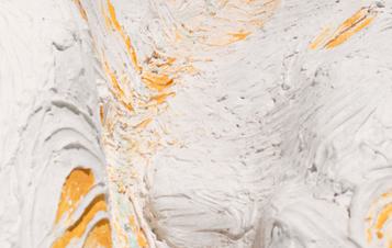 Detail of a textured white sculpture with yellow accents.