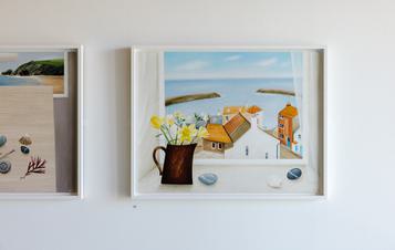 Two framed still life paintings displayed on a gallery wall.