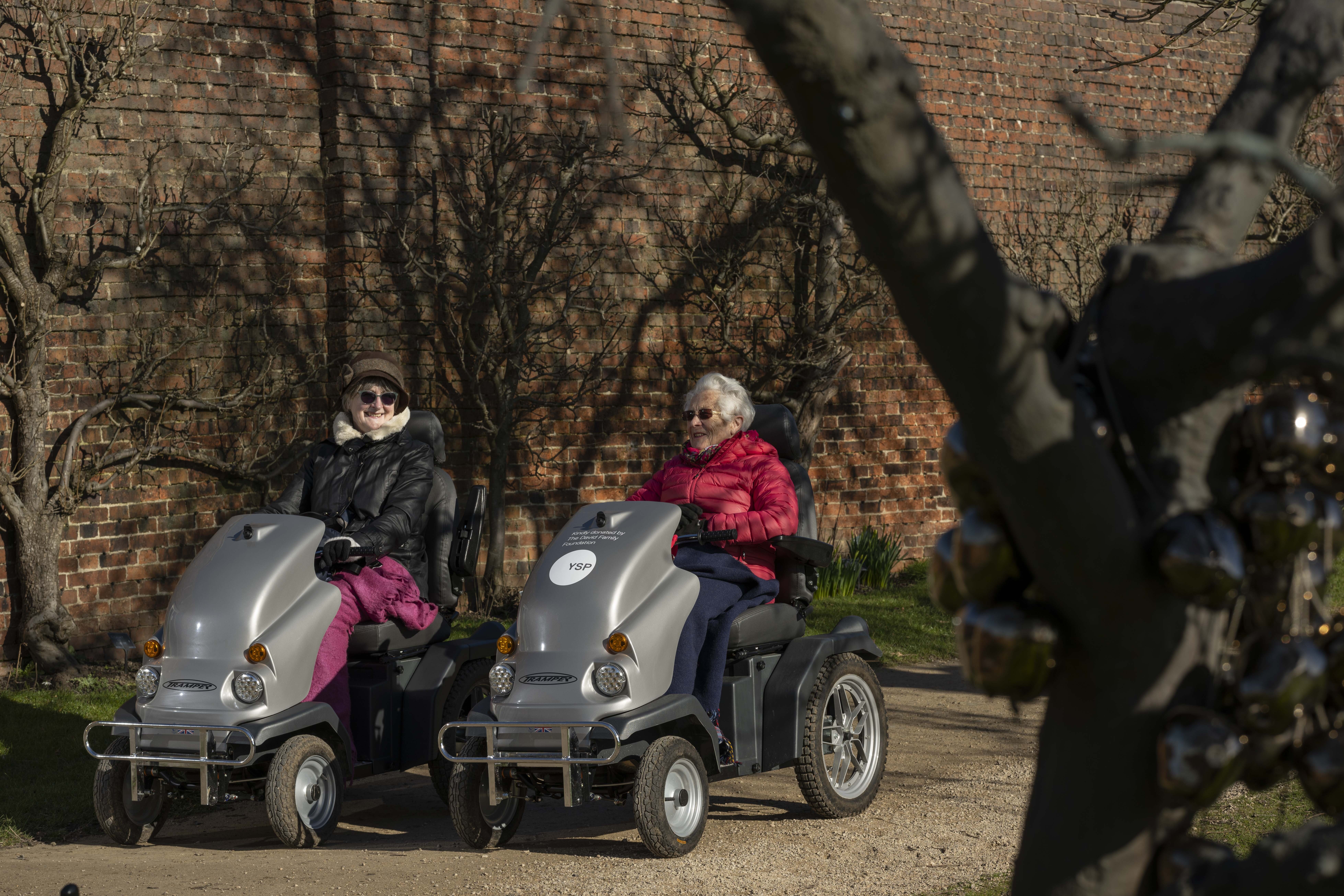 A pair of visitors using tramper mobility scooters.