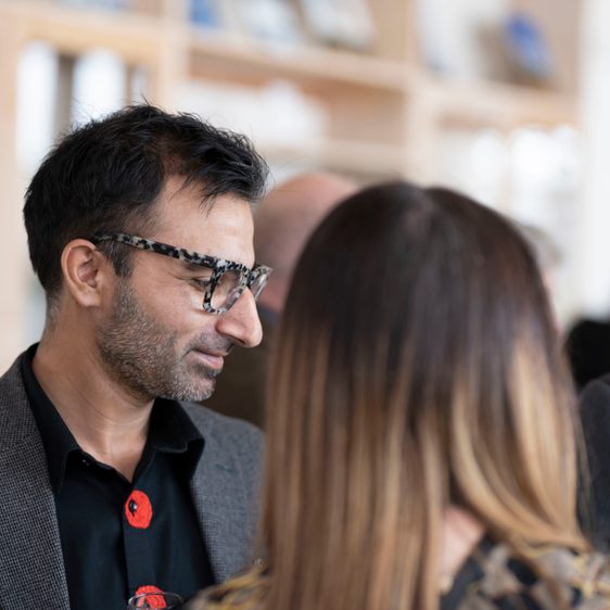 A man in glasses reading a card.