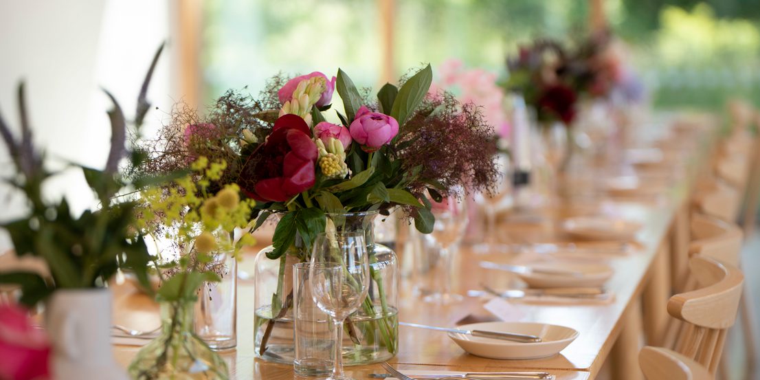 Flowers in vases on a set table.