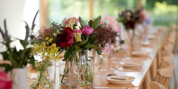 Flowers in vases on a set table.
