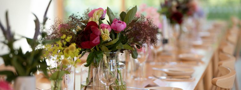 Flowers in vases on a set table.
