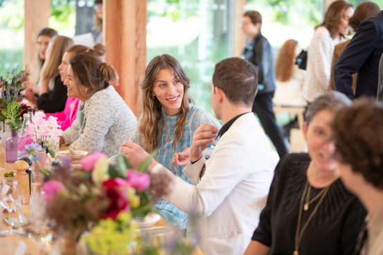 People talking, seated at a long table in The Weston.