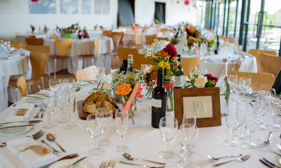 A table, set with glasses candles and wedding favours.