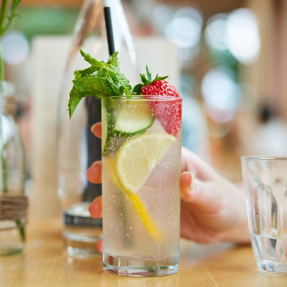 Refreshing drink with chopped lemons, cucumber and strawberries