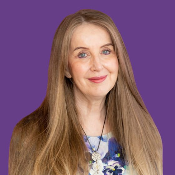 A headshot of a white woman with long hair and blue eyes