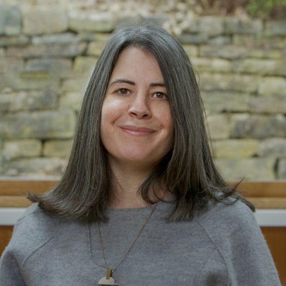 A woman with shoulder length brown hair looking to camera.