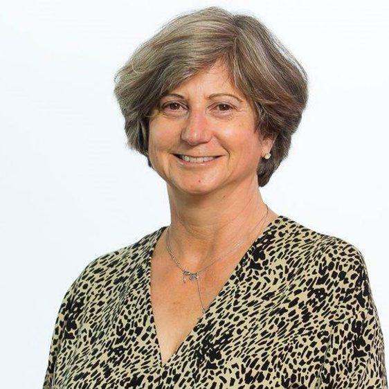 A white woman with grey hair, wearing a leopard print top