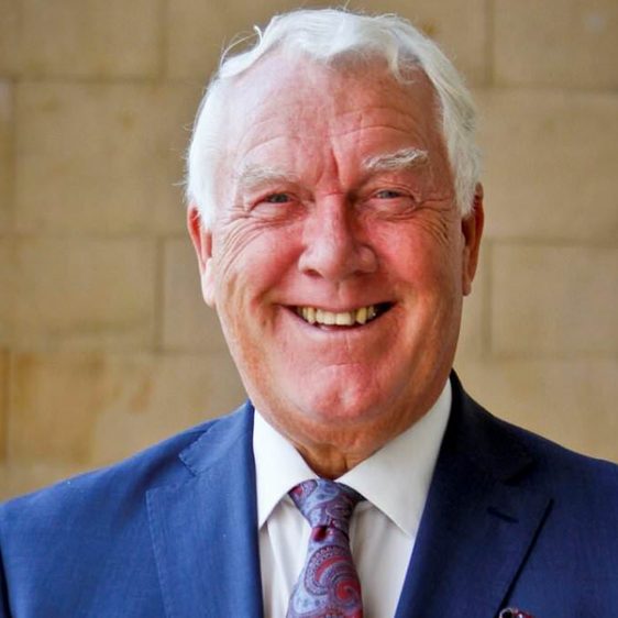 A smiling man with white hair