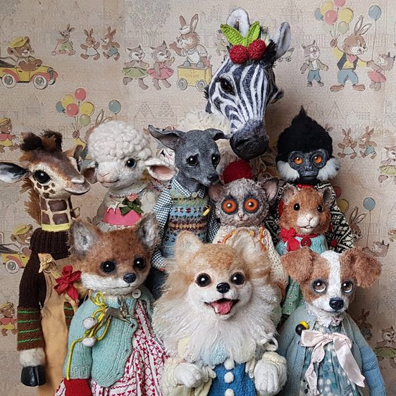 A group of animal figures dressed in vintage dolls clothing.