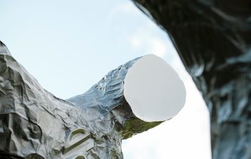 A close up of a silver figure with a flat featureless face