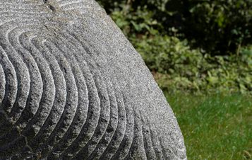 A close up of a granite sculpture with intricate carved lines