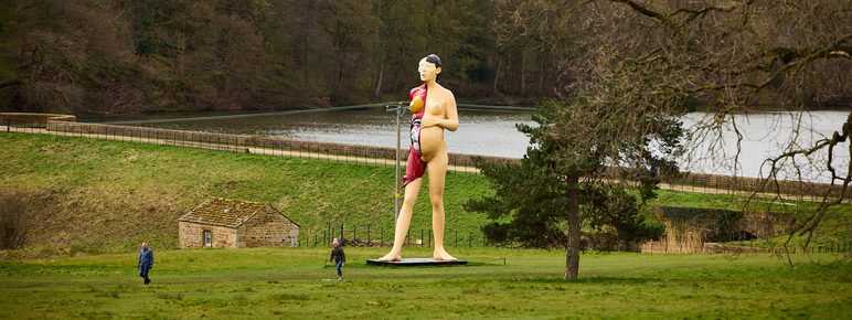 A large sculpture of a pregnant woman, with half her skin removed to reveal muscles and internal organs.