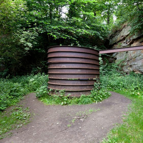 A cylindrical rusted metal sculpture