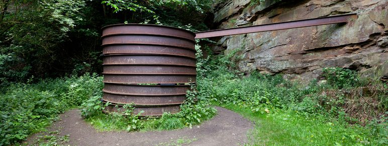 A cylindrical rusted metal sculpture
