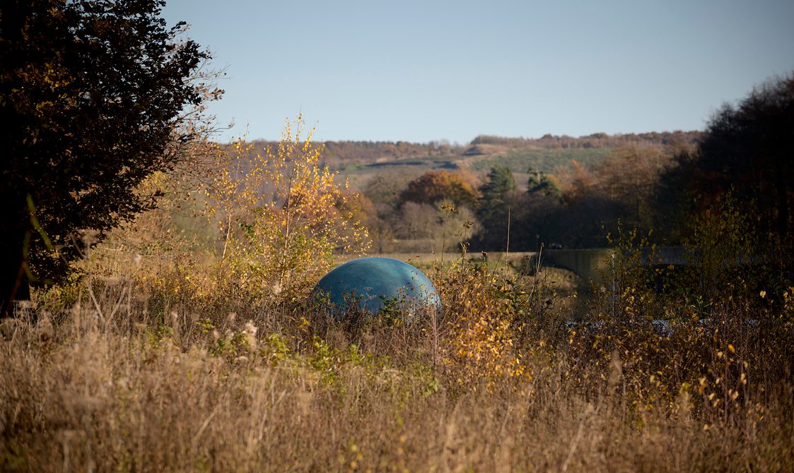 Gavin Turk – Oeuvre (Verdigris) 2019 peaking through long grass at Yorkshire Sculpture Park