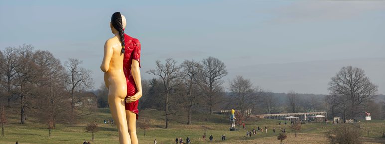 A large sculpture of a pregnant woman, with half her skin removed to reveal muscles and internal organs.