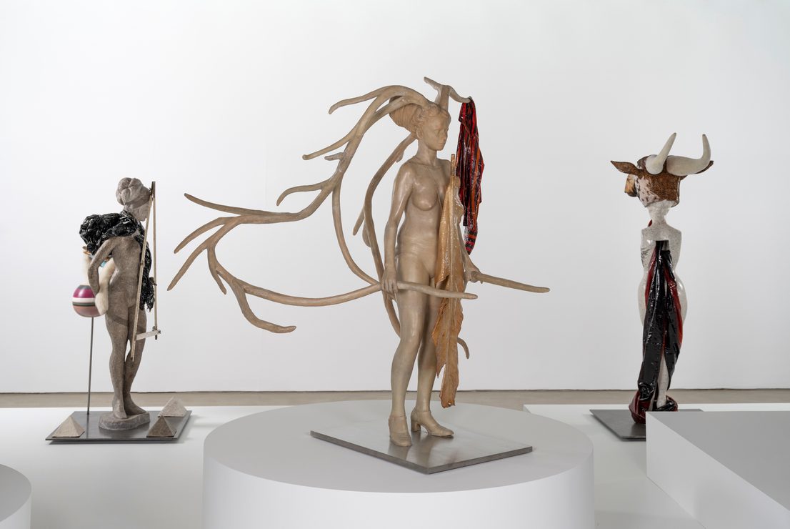 A display of human-animal hybrid figures on plinths