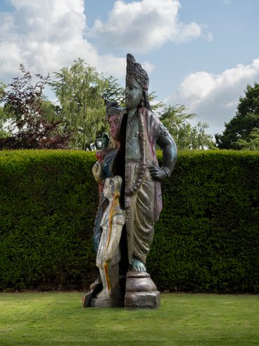 A colourful bronze sculpture of a woman dressed in a sari