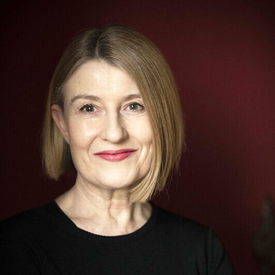 A woman with shoulder length brown hair looking directly to camera.