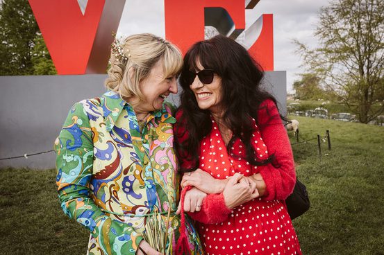 Two white women looking at each other and smiling.