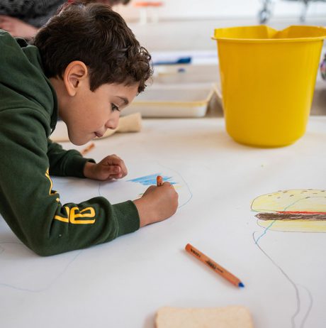 A child drawing on a large piece of paper