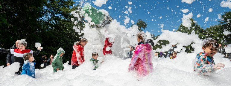 A group of children playing in a cloud of foam