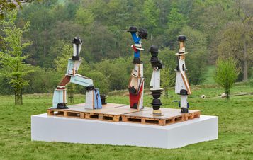 Four sculptures with fedora, boater and trilby hats resting on top.