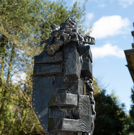 Close up of a bronze abstract figure outdoors.