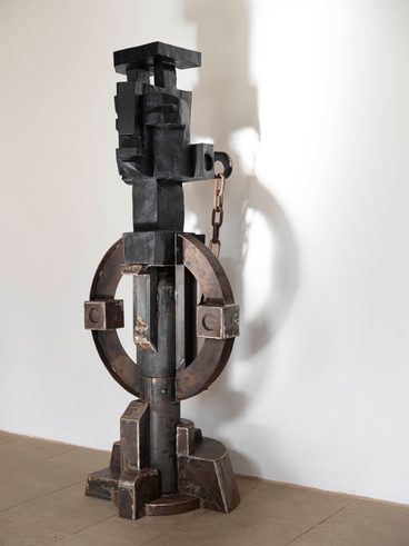 A carved wood and welded metal totem