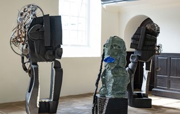 A collection of carved wood and ceramic figures in a gallery.