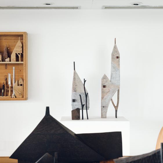 A display of miniature carved wooden houses.