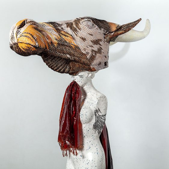 A sculpture of a woman with a giant cows head.