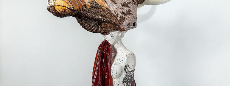 A sculpture of a woman with a giant cows head.