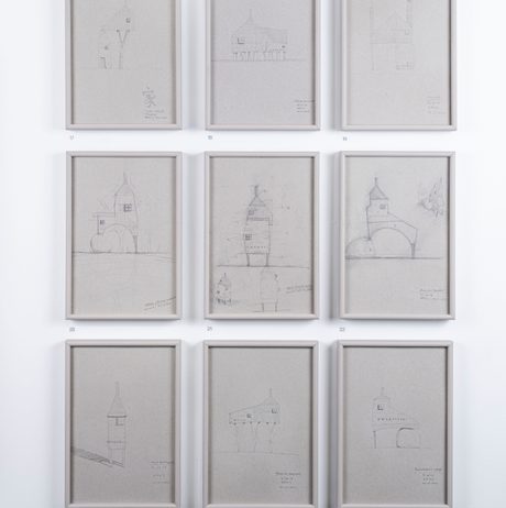 Nine framed pencil drawings of miniature houses.