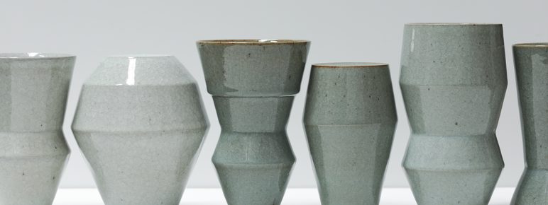 A row of glazed green and grey vases