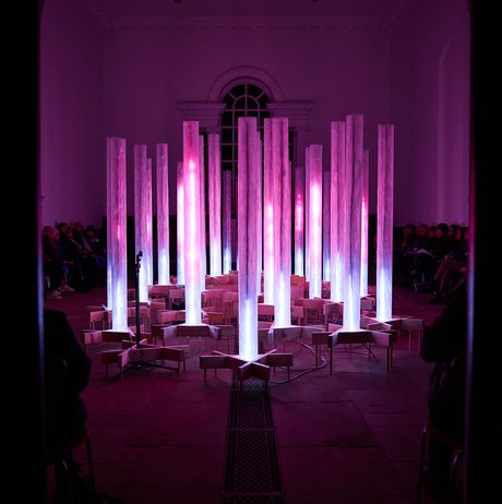 An installation of pink and blue glowing columns.