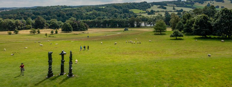 An aerial image of a hillside, with sculptures and walkers