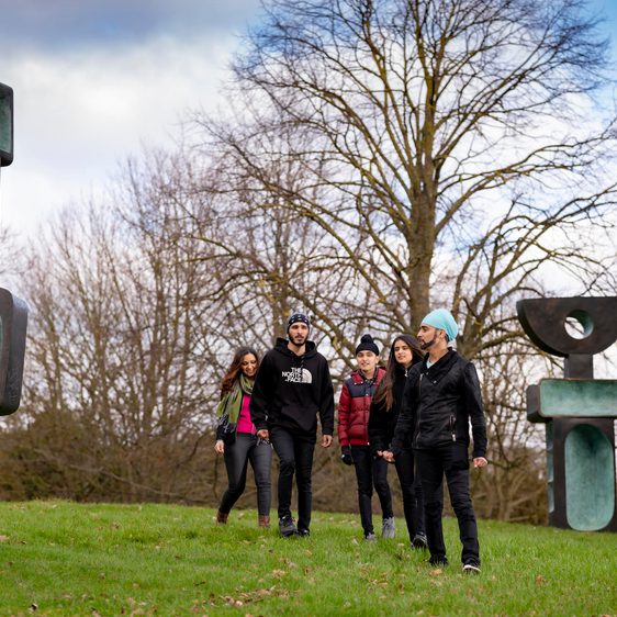 A family look at Barbara Hepworth's Family of Man in the country park.