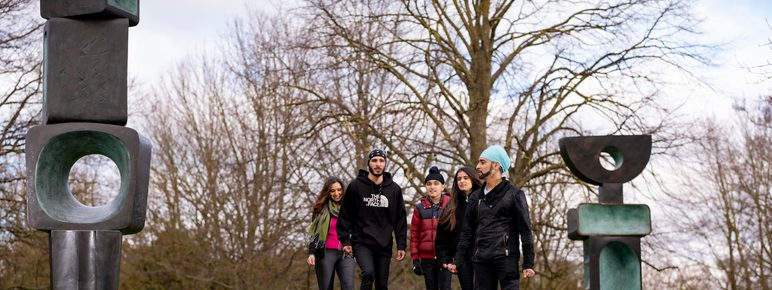 A family look at Barbara Hepworth's Family of Man in the country park.