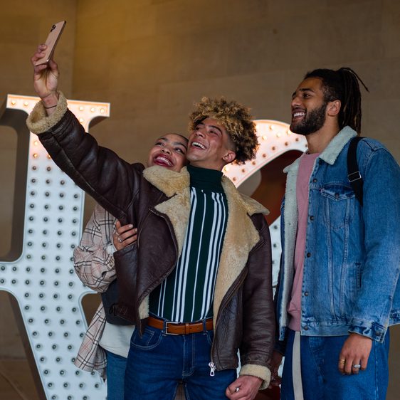 a group of friends taking a selfie in front of a sculpture at YSP
