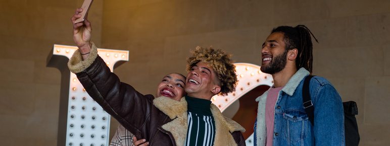 a group of friends taking a selfie in front of a sculpture at YSP