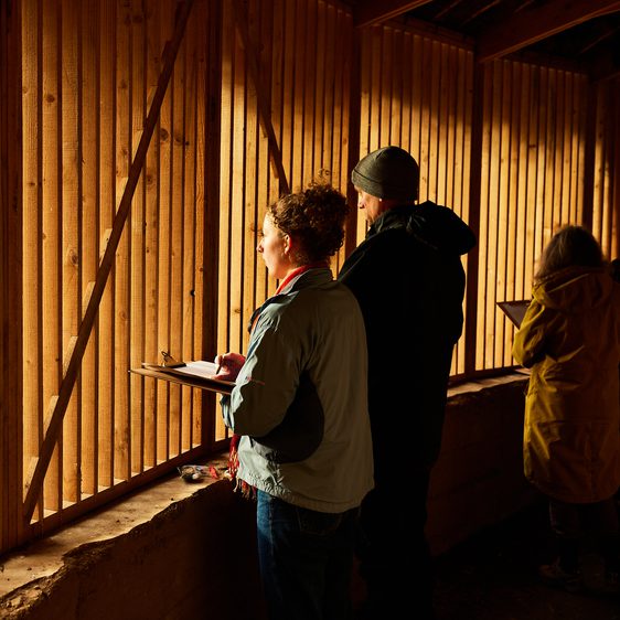 Three visitors draw on clipboards in Silence.